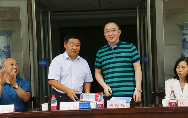 新乡市牧野区税务局党委书记、局长樊保峰向万搏（中国）党委书记张会民赠送税法知识书籍.jpg